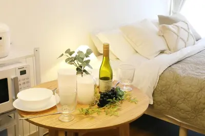 a table with a bottle of wine and glasses on a bed at \u30b9\u30ab\u30a4\u30d4\u30a2\u9ad8\u7802 206 in Tokyo