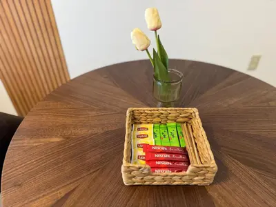a wooden table with a basket with books and a vase with flowers at MIKASA guesthouse in Tokyo