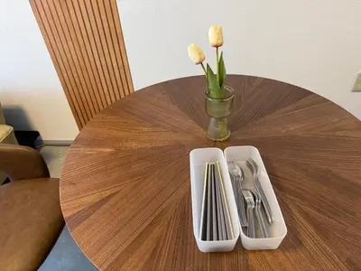 a wooden table with a vase of flowers and utensils at MIKASA guesthouse in Tokyo