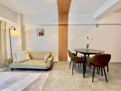 a living room with a couch and a table and chairs at MIKASA guesthouse in Tokyo