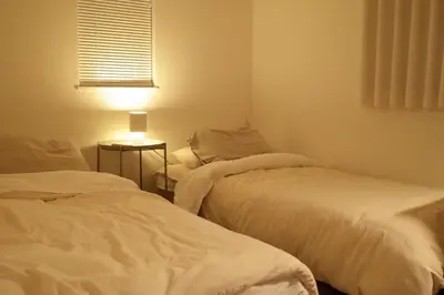 two beds in a small room with a lamp at Tokyo Designer Guest House in central Tokyo in Tokyo