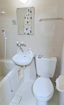a white bathroom with a toilet and a sink at Senju 103, Relaxed Tokyo Studio in Tokyo