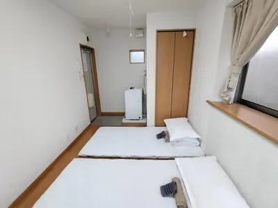a room with two beds and a refrigerator at Senju 203, Relaxed Tokyo Loft in Tokyo