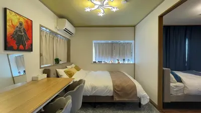 a bedroom with a bed and a table and chairs at Anime2 in Tokyo