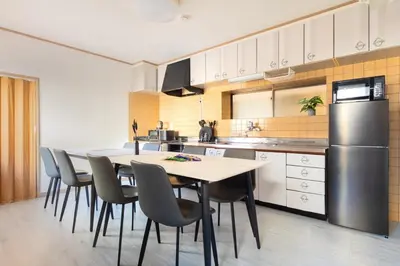 a kitchen with a table and chairs and a refrigerator at Anime2 in Tokyo