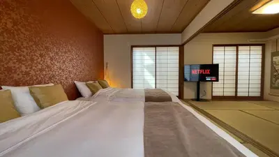 a large white bed in a room with a tv at Anime2 in Tokyo