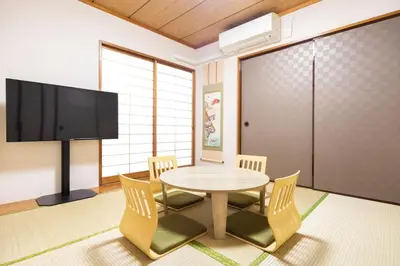 a dining room with a table and chairs and a tv at Anime2 in Tokyo