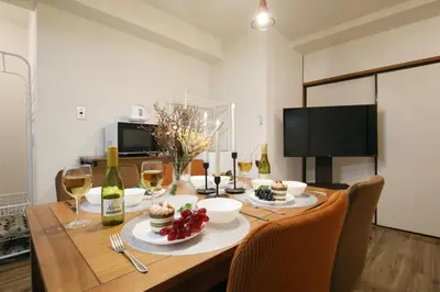 a dining room table with glasses of wine and food at \u5bdb\u6c38\u5bfa\u5742\u30cf\u30a4\u30e0 501 in Tokyo