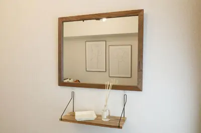 a mirror on a wall with a vase on a shelf at \u5bdb\u6c38\u5bfa\u5742\u30cf\u30a4\u30e0 501 in Tokyo