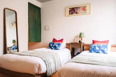 a bedroom with two beds and a mirror at Mi-HOTEL MIYA SHINJUKU in Tokyo