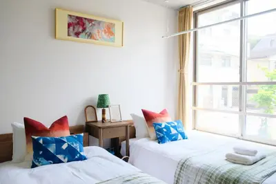 two beds in a room with a window at Mi-HOTEL MIYA SHINJUKU in Tokyo