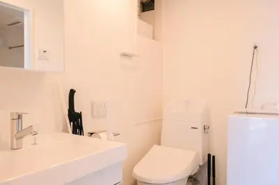 a white bathroom with a toilet and a sink at Mi-HOTEL MIYA SHINJUKU in Tokyo