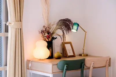 a table with a lamp and a vase on it at Mi-HOTEL MIYA SHINJUKU in Tokyo