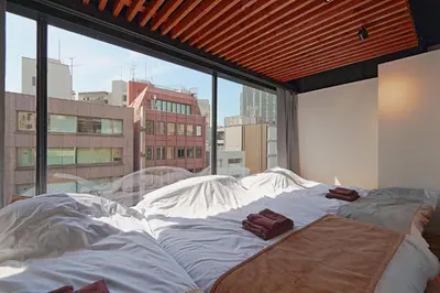 a large bed in a room with a large window at Steps from Shibuya Crossing Roof Top A in Tokyo