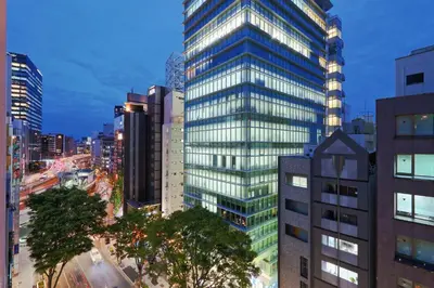 a tall glass building in the middle of a city at Steps from Shibuya Crossing Roof Top A in Tokyo