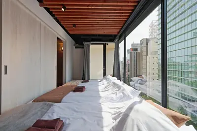 a large bed in a room with a large window at Steps from Shibuya Crossing Roof Top A in Tokyo