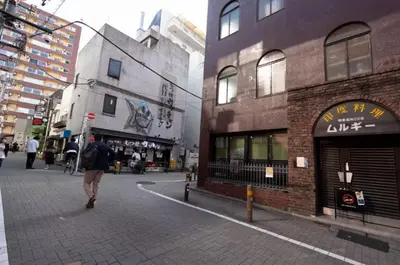 a person walking down a street next to buildings at Stay in the heart of Shibuya in Tokyo
