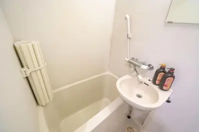 a white bathroom with a sink and a toilet at Stay in the heart of Shibuya in Tokyo