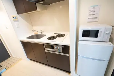 a small kitchen with a sink and a microwave at Stay in the heart of Shibuya in Tokyo