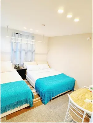a bedroom with two beds with blue sheets at \u6c60\u888b \u5de3\u9d28 YMhotel \u6700\u592718\u540d\u53ef-ikebukuro sugamo- in Tokyo