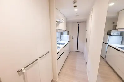 a kitchen with white cabinets and white appliances at LIVCITY Kinshicho 401 in Tokyo