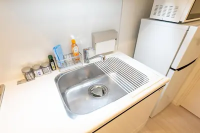 a kitchen with a sink and a refrigerator at LIVCITY Kinshicho 401 in Tokyo