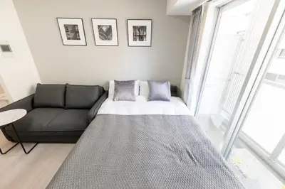a living room with a bed and a couch at LIVCITY Kinshicho 501 in Tokyo