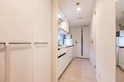 a kitchen with white cabinets and a hallway at LIVCITY Kinshicho 501 in Tokyo