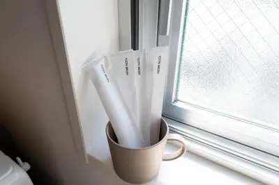 a cup sitting on a window sill with toothbrushes at LIVCITY Kinshicho 501 in Tokyo