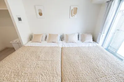 a bedroom with a large bed with white sheets and pillows at LIVCITY Kinshicho 601 in Tokyo