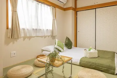 a bedroom with a bed and a table and a window at 2BR Apartment Only 2 Stops to Shinjuku Includes Baby Essentials & Luggage Hold in Tokyo