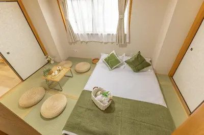 a small room with a bed with a mirror at 2BR Apartment Only 2 Stops to Shinjuku Includes Baby Essentials & Luggage Hold in Tokyo