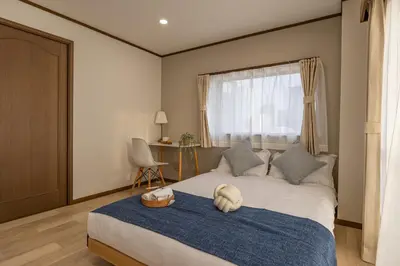 a bedroom with a bed with a blue blanket and a window at Near Shinjuku 2-Story Family & Group-Friendly Home 5 Bedrooms, Fits 14 Guests in Tokyo