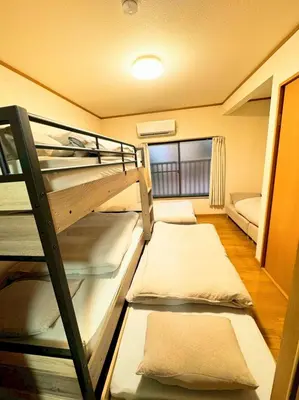 a room with three bunk beds and a couch at jr\u65b0\u5c0f\u5ca9\u99c5\u307e\u3067\u5f92\u6b698\u5206,\u8cb8\u5207\u89b3\u5149\u6700\u9069,\u6771\u4eac\u99c5\u307e\u306720\u5206 in Tokyo