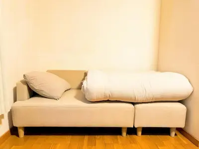 a white couch with a blanket on top of it at jr\u65b0\u5c0f\u5ca9\u99c5\u307e\u3067\u5f92\u6b698\u5206,\u8cb8\u5207\u89b3\u5149\u6700\u9069,\u6771\u4eac\u99c5\u307e\u306720\u5206 in Tokyo
