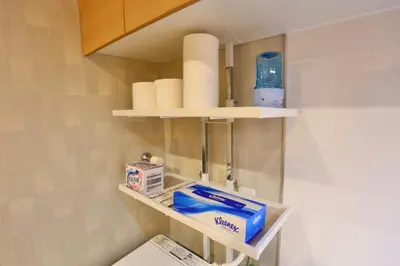 a bathroom with a shelf with toiletries on it at New 2BR Ueno Home 2 Minutes Walk to Metro Station in Tokyo