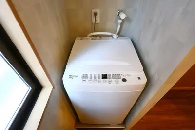 a washing machine in a corner of a room at New 2BR Ueno Home 2 Minutes Walk to Metro Station in Tokyo