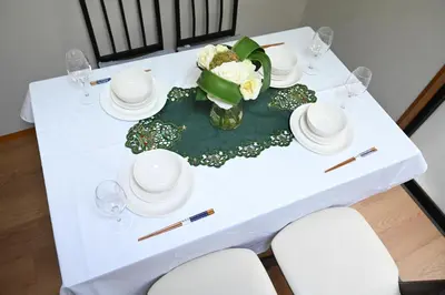 a white table with plates and glasses and a vase of flowers at Two bathrooms, two toilets 6 mins walking distance from Keisei Takasago Station in Tokyo