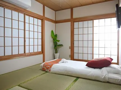 a room with a bed in a room with windows at Two bathrooms, two toilets 6 mins walking distance from Keisei Takasago Station in Tokyo