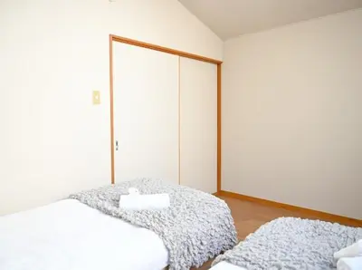 a bedroom with two beds and a mirror at Two bathrooms, two toilets 6 mins walking distance from Keisei Takasago Station in Tokyo