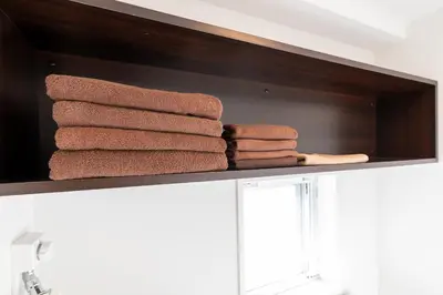 a pile of towels on a shelf in a bathroom at LIVCITY Kinshicho 801 in Tokyo