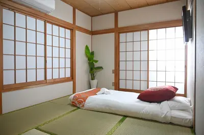 a room with a bed in a room with windows at \u5171\u4eab\u536b\u6d74 \u72ec\u7acb\u5367\u5ba4 \u6210\u7530\u673a\u573a \u7fbd\u7530\u673a\u573a \u94f6\u5ea7\u65b0\u6865\u4e00\u7ebf\u76f4\u8fbe in Tokyo