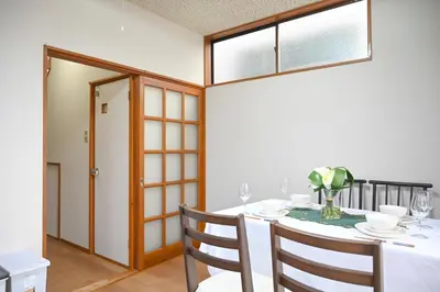 a dining room with a white table and chairs at \u5171\u4eab\u536b\u6d74 \u72ec\u7acb\u5367\u5ba4 \u6210\u7530\u673a\u573a \u7fbd\u7530\u673a\u573a \u94f6\u5ea7\u65b0\u6865\u4e00\u7ebf\u76f4\u8fbe in Tokyo