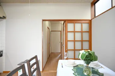 a dining room table with a vase of flowers on it at \u5171\u4eab\u536b\u6d74 \u72ec\u7acb\u5367\u5ba4 \u6210\u7530\u673a\u573a \u7fbd\u7530\u673a\u573a \u94f6\u5ea7\u65b0\u6865\u4e00\u7ebf\u76f4\u8fbe in Tokyo