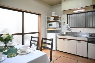 a kitchen with a table with a white table cloth at \u5171\u4eab\u536b\u6d74 \u72ec\u7acb\u5367\u5ba4 \u6210\u7530\u673a\u573a \u7fbd\u7530\u673a\u573a \u94f6\u5ea7\u65b0\u6865\u4e00\u7ebf\u76f4\u8fbe in Tokyo