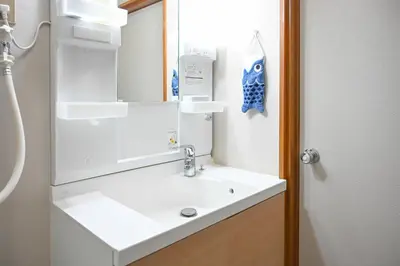 a bathroom with a white sink and a mirror at \u5171\u4eab\u536b\u6d74 \u72ec\u7acb\u5367\u5ba4 \u6210\u7530\u673a\u573a \u7fbd\u7530\u673a\u573a \u94f6\u5ea7\u65b0\u6865\u4e00\u7ebf\u76f4\u8fbe in Tokyo