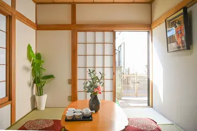 a living room with a table and a window at \u5171\u4eab\u536b\u6d74 \u72ec\u7acb\u5367\u5ba4 \u6210\u7530\u673a\u573a \u7fbd\u7530\u673a\u573a \u94f6\u5ea7\u65b0\u6865\u4e00\u7ebf\u76f4\u8fbe in Tokyo