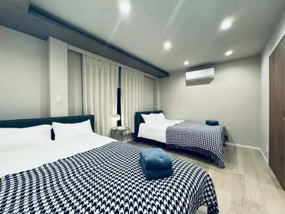 a bedroom with two beds and a window at Higashiasakusa house 1F-TT0365 in Tokyo