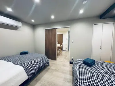 a bedroom with two beds and a table in a room at Higashiasakusa house 1F-TT0365 in Tokyo