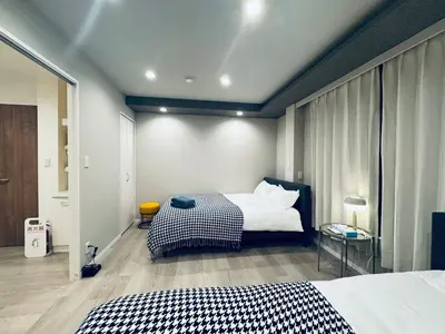 a bedroom with two beds and a table in it at Higashiasakusa house 1F-TT0365 in Tokyo